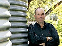 Conjoint Associate Professor Peter Coombes with his household rainwater tanks made from AQUAPLATE&reg; steel.