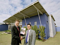 Ian Holloway (left) and Kevin Soh (BlueScope Steel) in front of the Skillion Retreat display featuring a roof made from COLORBOND&reg; steel and wall cladding made from ZINCALUME&reg; steel.