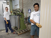 Chris Fullerton (left) and Maurice Ngatoko from Coast and Country Water Tanks, a member of the STEEL BY&trade; Brand Partnership Program, rollform tanks from AQUAPLATE&reg; steel.