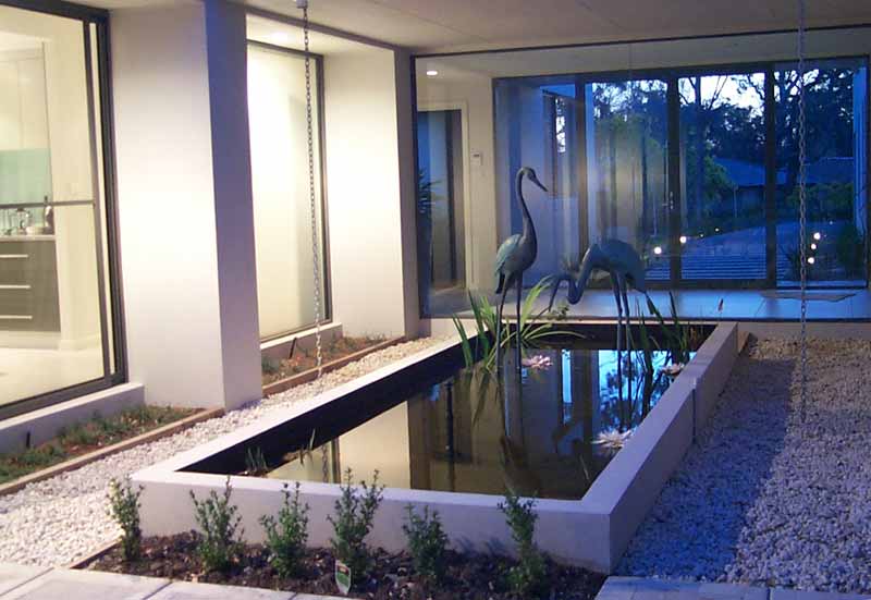 A reflection pond is located between the two wings of the house in Canberra where COLORBOND® has allowed versatility of design.