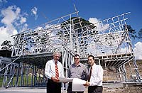 Boss Homes' John White (centre), Steel House Frames Australia's Jim Tamai (left), Mario Girardo outside the Queensland display house which features framing and roof trusses made from ZINCALUME&reg; steel