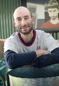 Melbourne artist, Andre Sardone, with his distinctive self portrait in the background